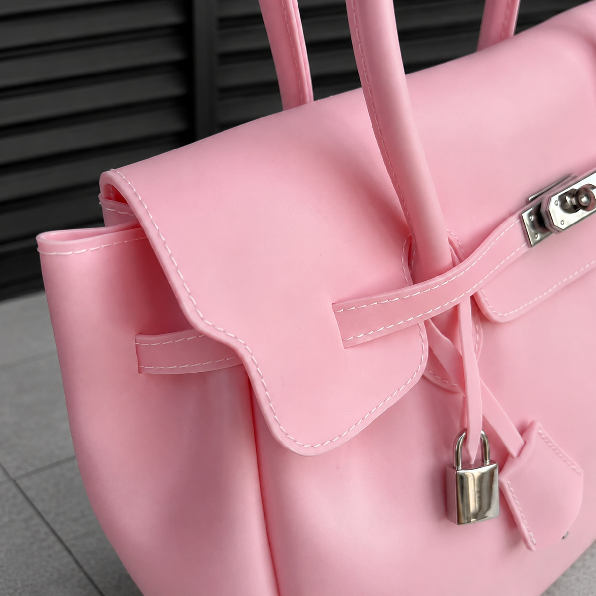 Close-up of the Jelly Firkin Blush padlock clasp and stitched handles
