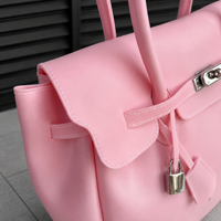 Close-up of the Jelly Firkin Blush padlock clasp and stitched handles