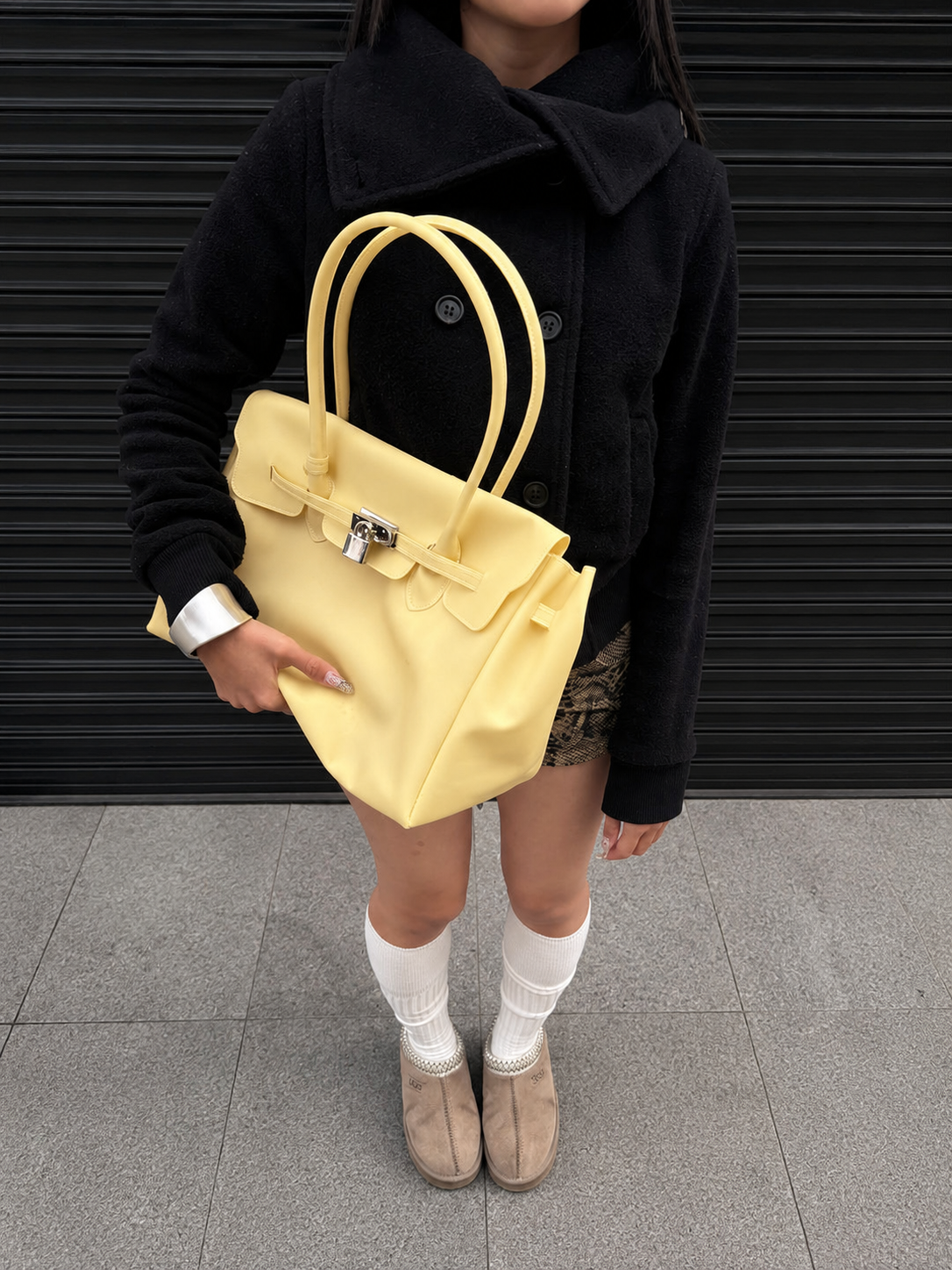 Jelly Firkin Butter yellow bag carried by hand with a casual fall outfit
