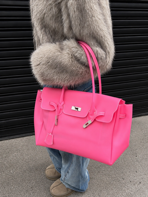 Model holding the Jelly Firkin Cherry Blush pink bag with a faux-fur coat