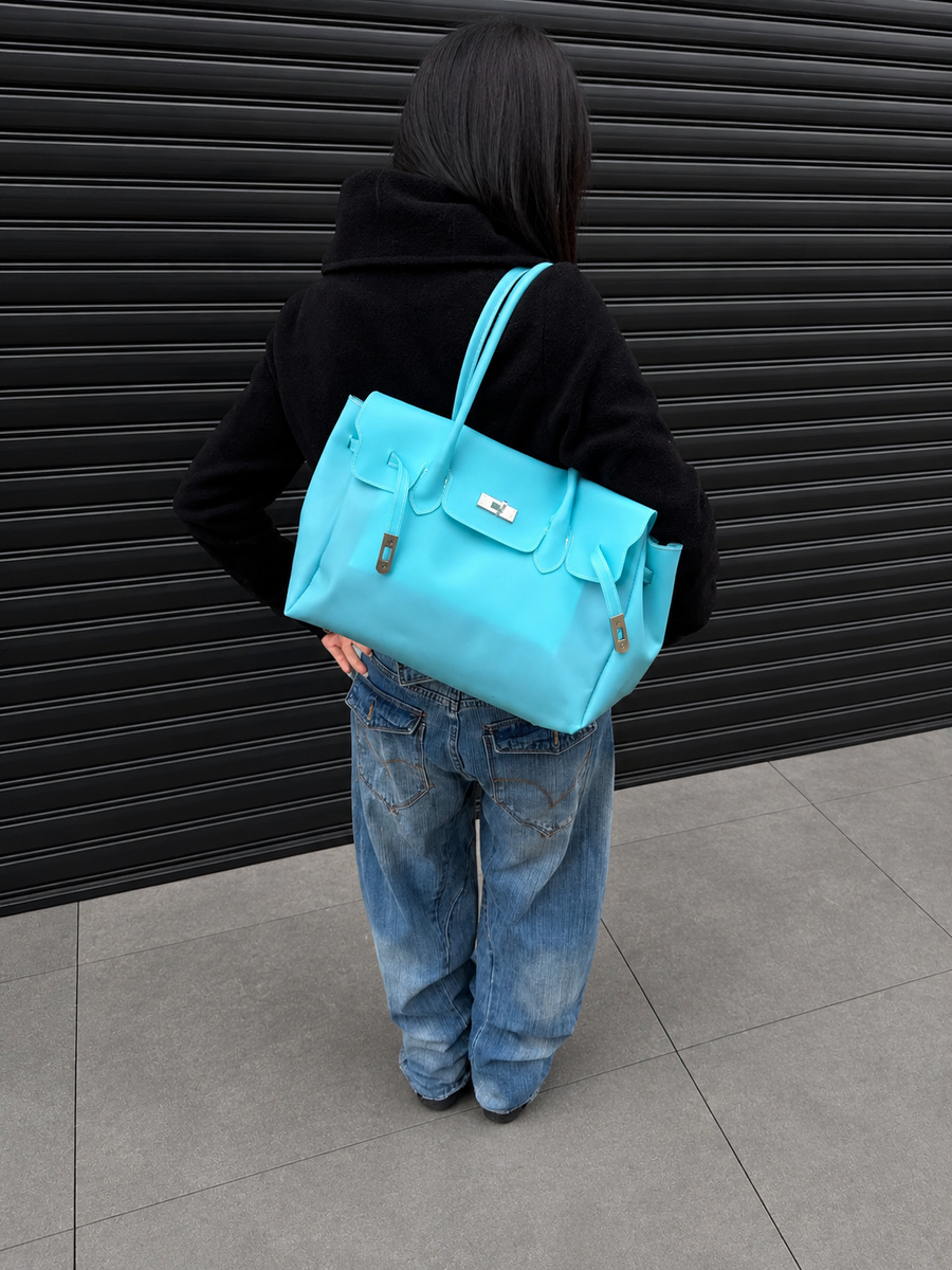 Model wearing the Jelly Firkin Lagoon turquoise shoulder bag with jeans