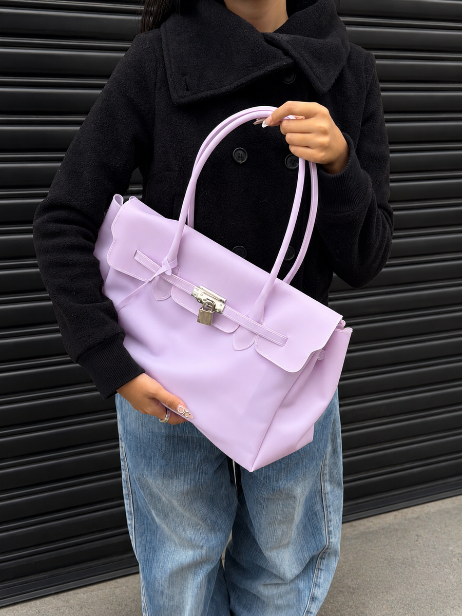 Model holding the Jelly Firkin Lilac purple bag with a black coat and jeans